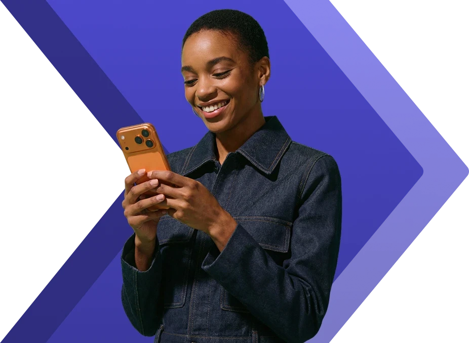 Cliente sorrindo enquanto usa o aplicativo IDX Brasil no celular para negociar a compra de um imóvel