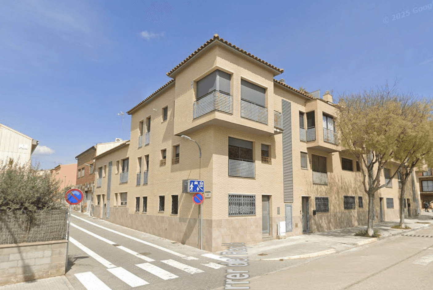 A modern brick house with a two-car garage, well-manicured lawn, and clear blue sky in the background.