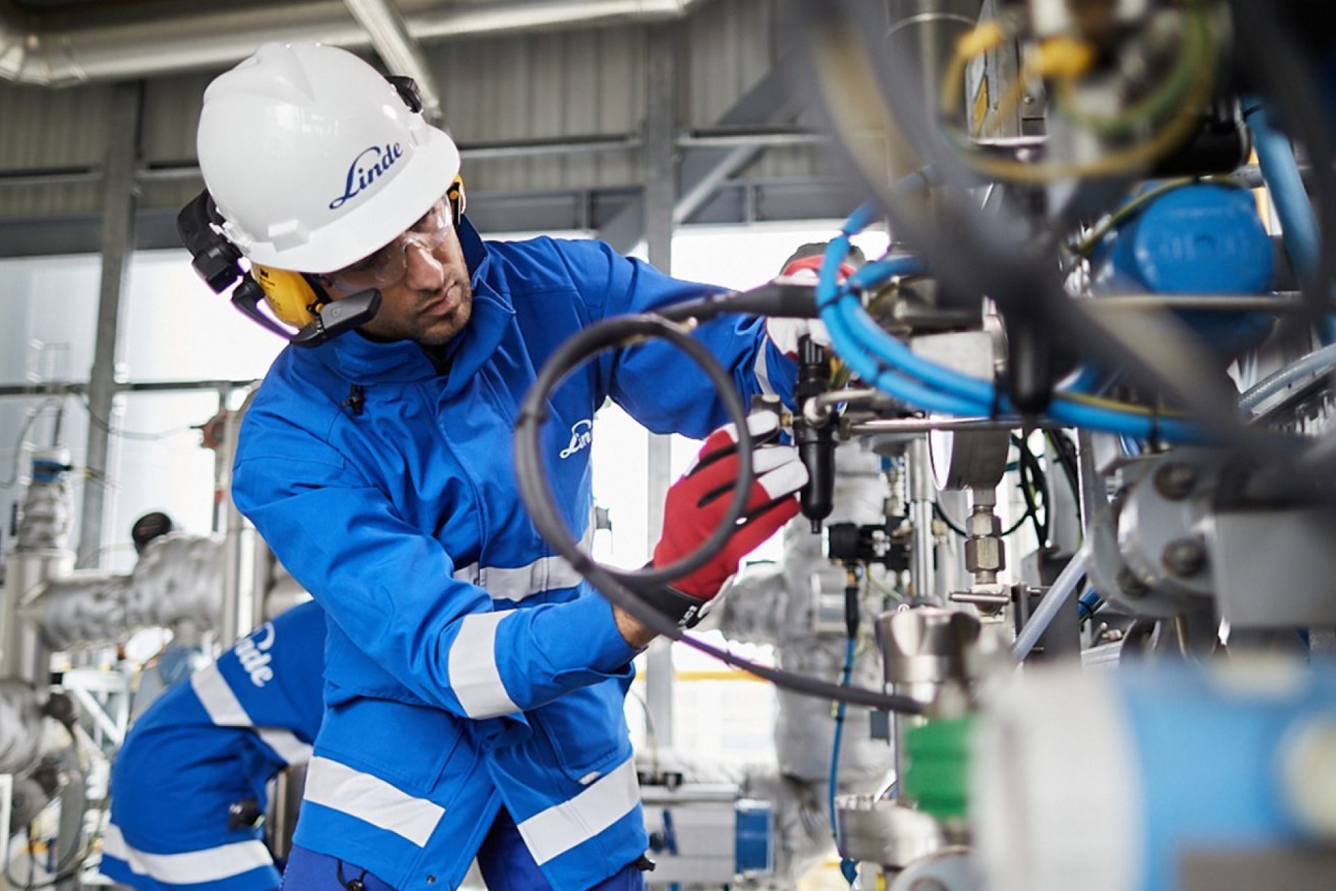 A photo of an industrial engineer wearing a RealWear headset and working on some equipment