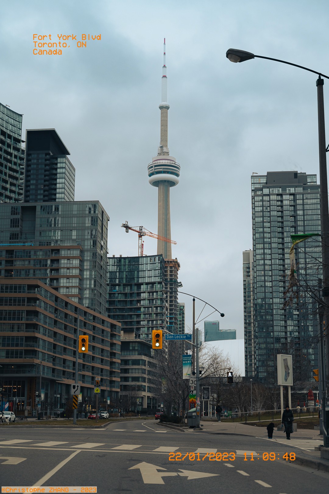Vue urbaine de la CN Tower émergeant entre les immeubles modernes de Toronto.