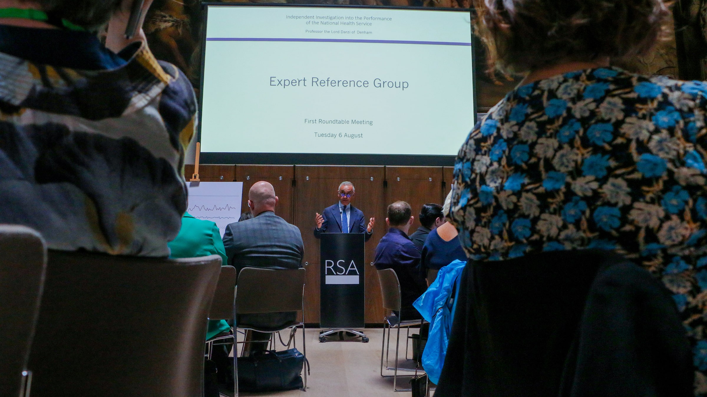 Lord Darzi delivers open remarks at a lectern at an NHS roundtable event in London