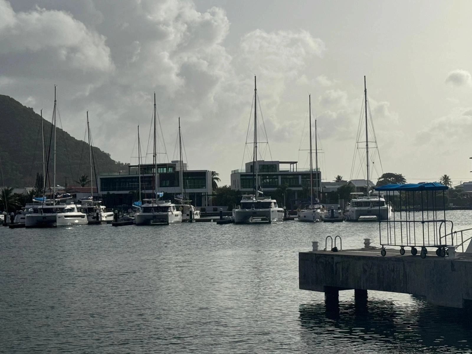Rodney Bay Marina, St. Lucia, with moored catamarans and sailboats in front of the modern Atelier International residences and hillside beyond.