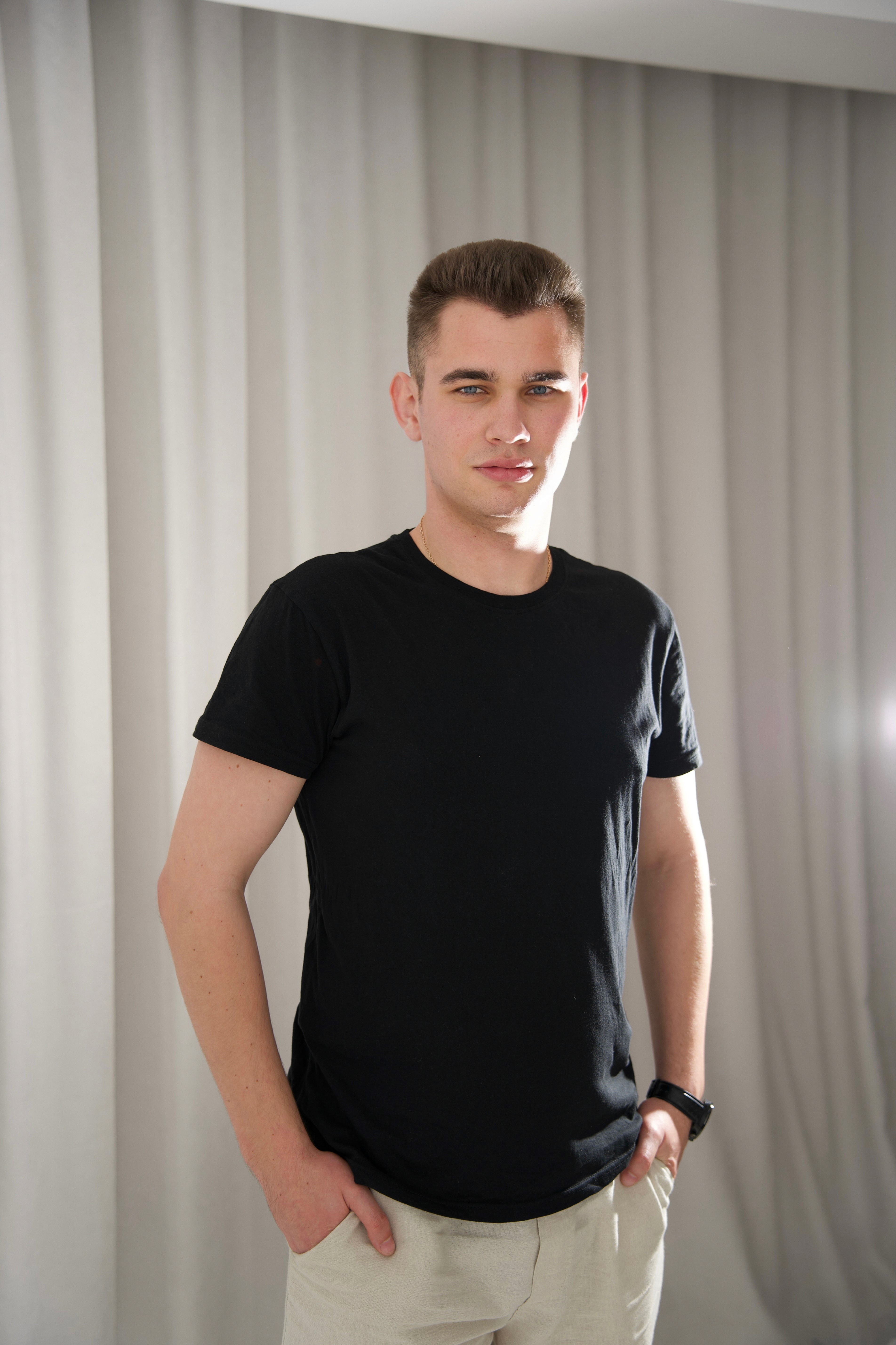 Profile portrait of a man in a white shirt against a light background