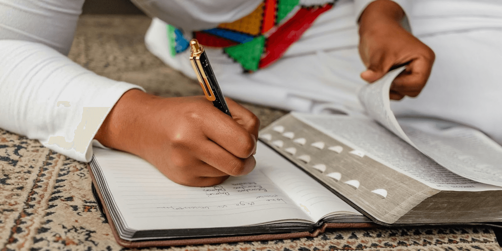 Image shows a person writing in a notebook, illustrating Ming Ye’s calligraphy education and InkBridge's commitment to preserving cultural heritage.