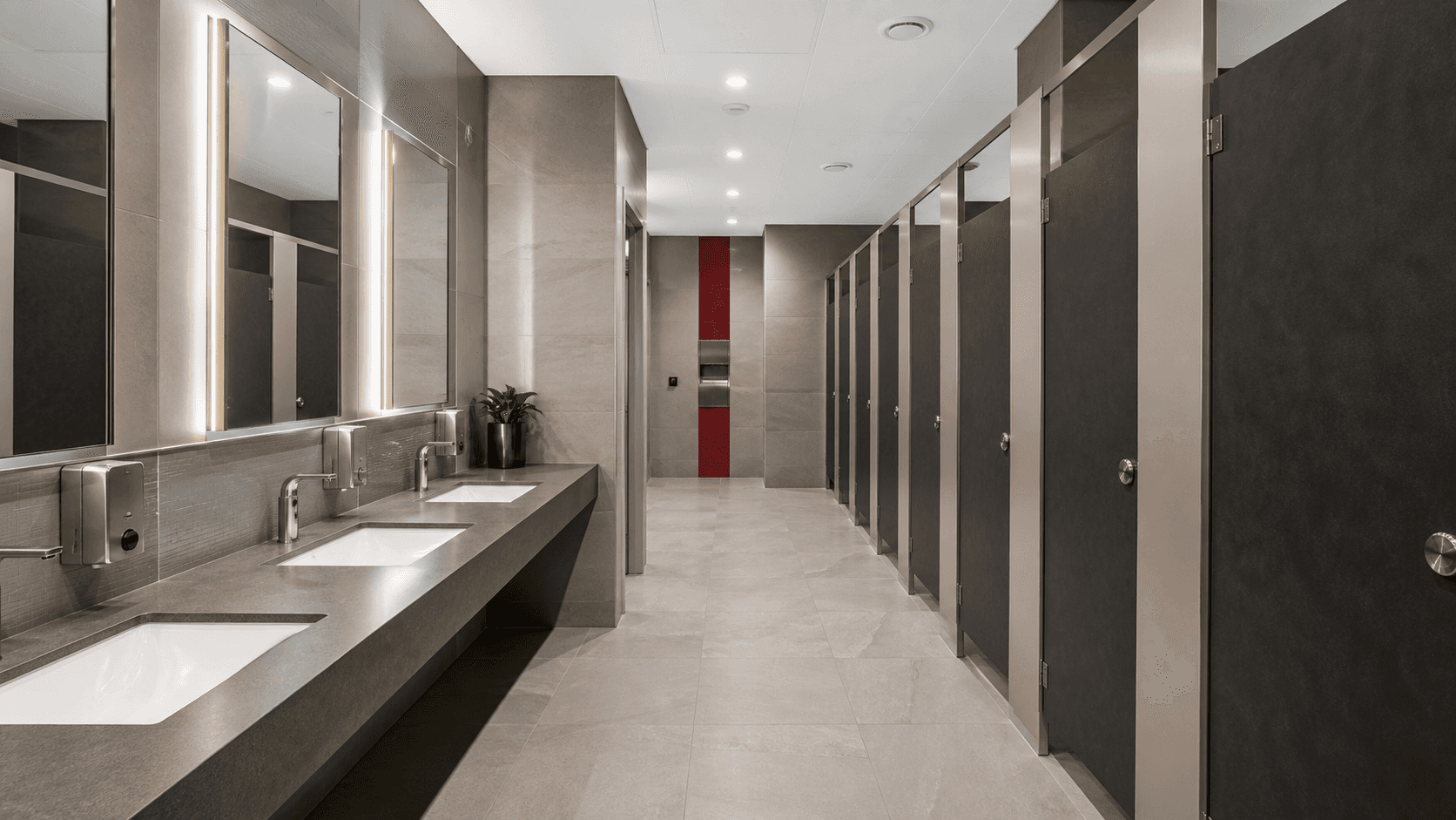 Modern accessible commercial washroom refurbishment with durable cubicles and sensor basins