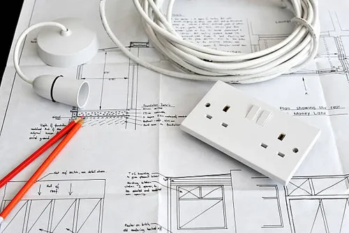 electrician installing wiring with yellow hardhat