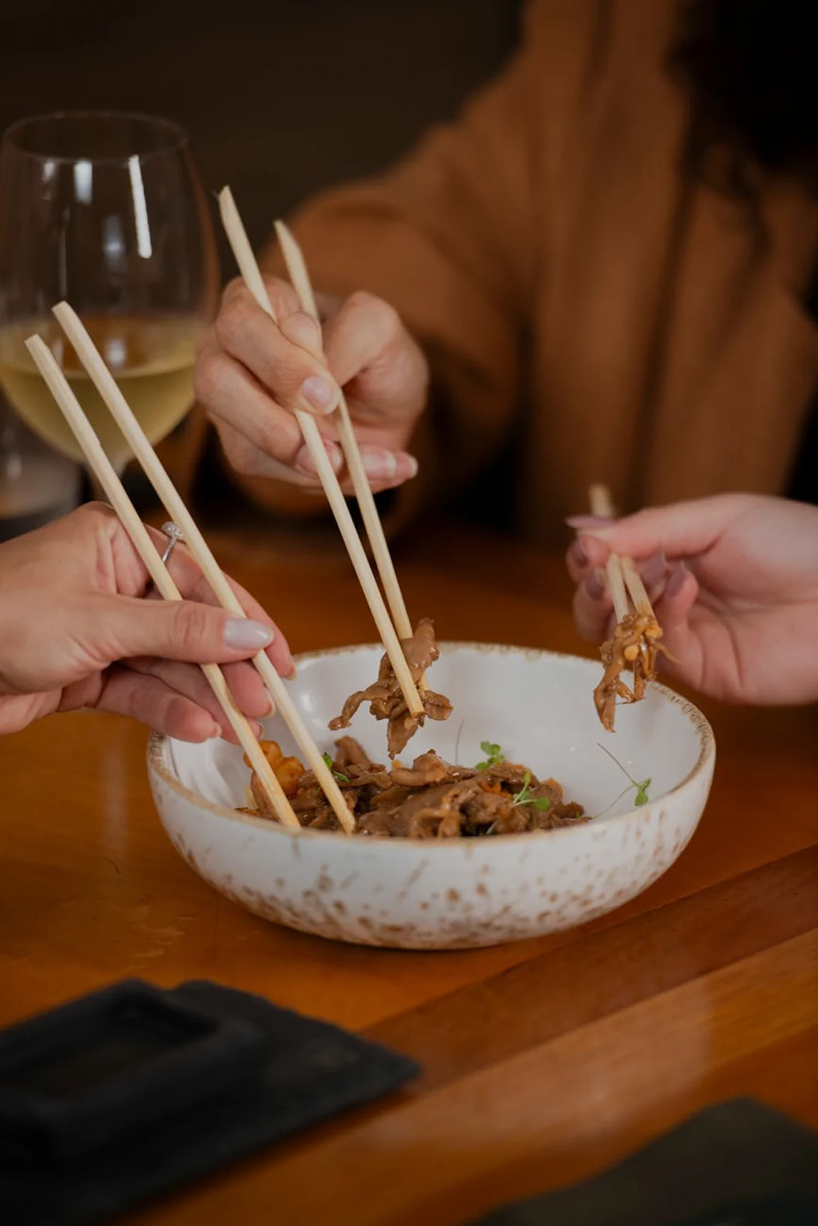 Guests sharing a meal together from a communal bowl during a group dining experience.