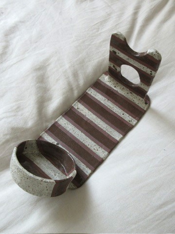 Maroon and white striped ceramic wine holder with cutout detail