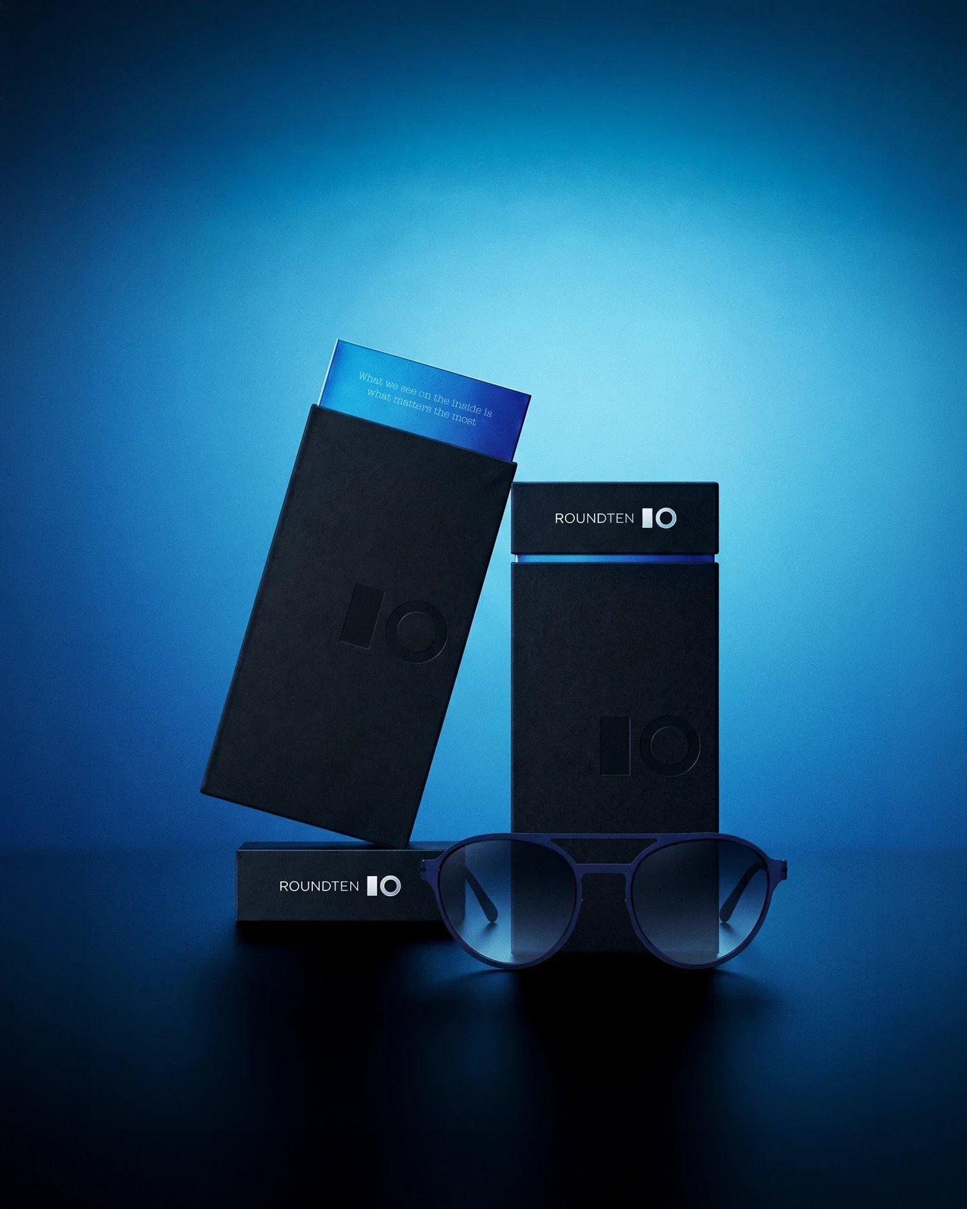 Roundten packaging with a sliding blue card and sunglasses in blue light, packaging design by Sebastian Saavedra