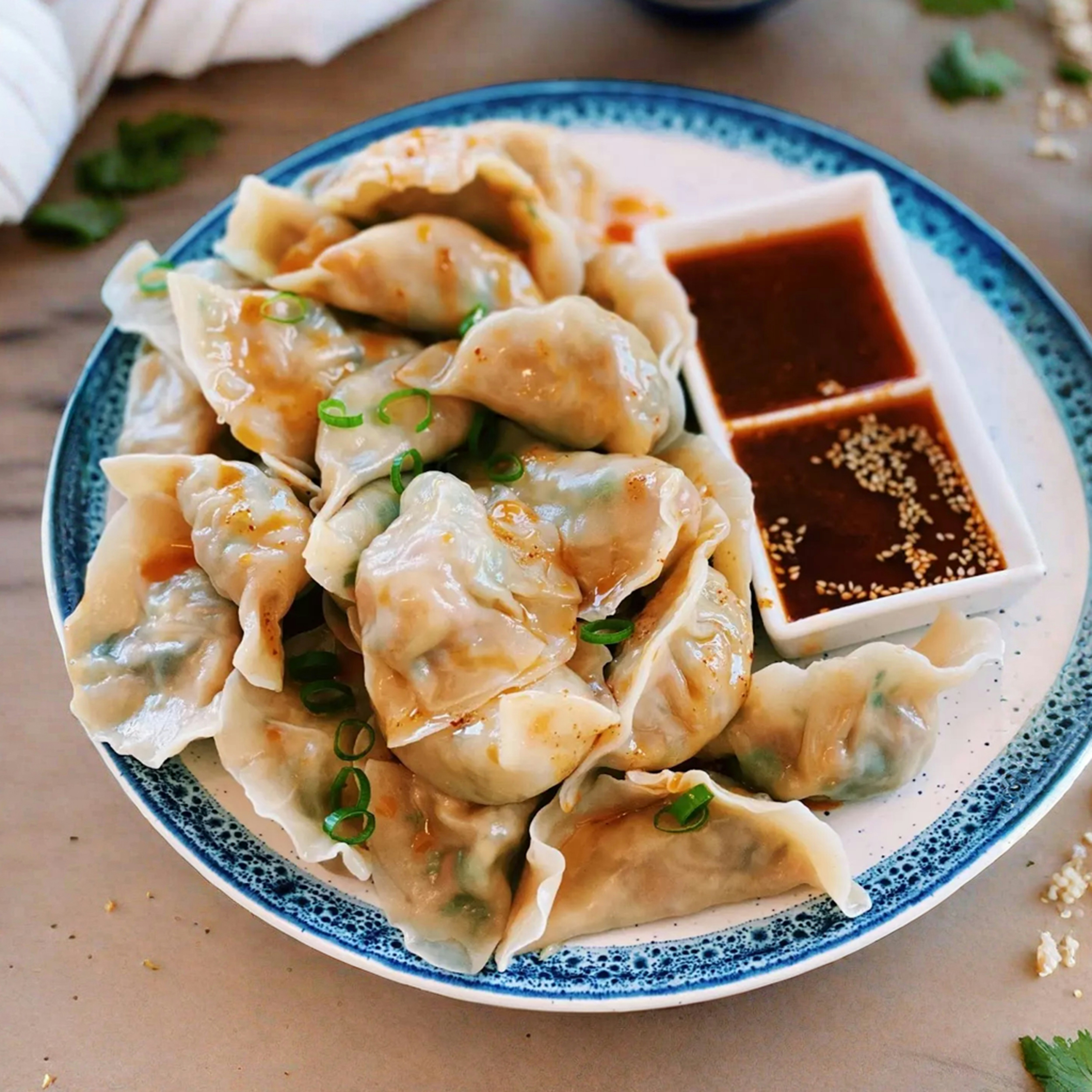 a plate of dumplings with dipping sauce
