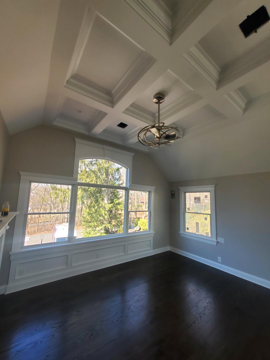 Custom millwork featuring coffered ceiling, detailed trim, and large windows