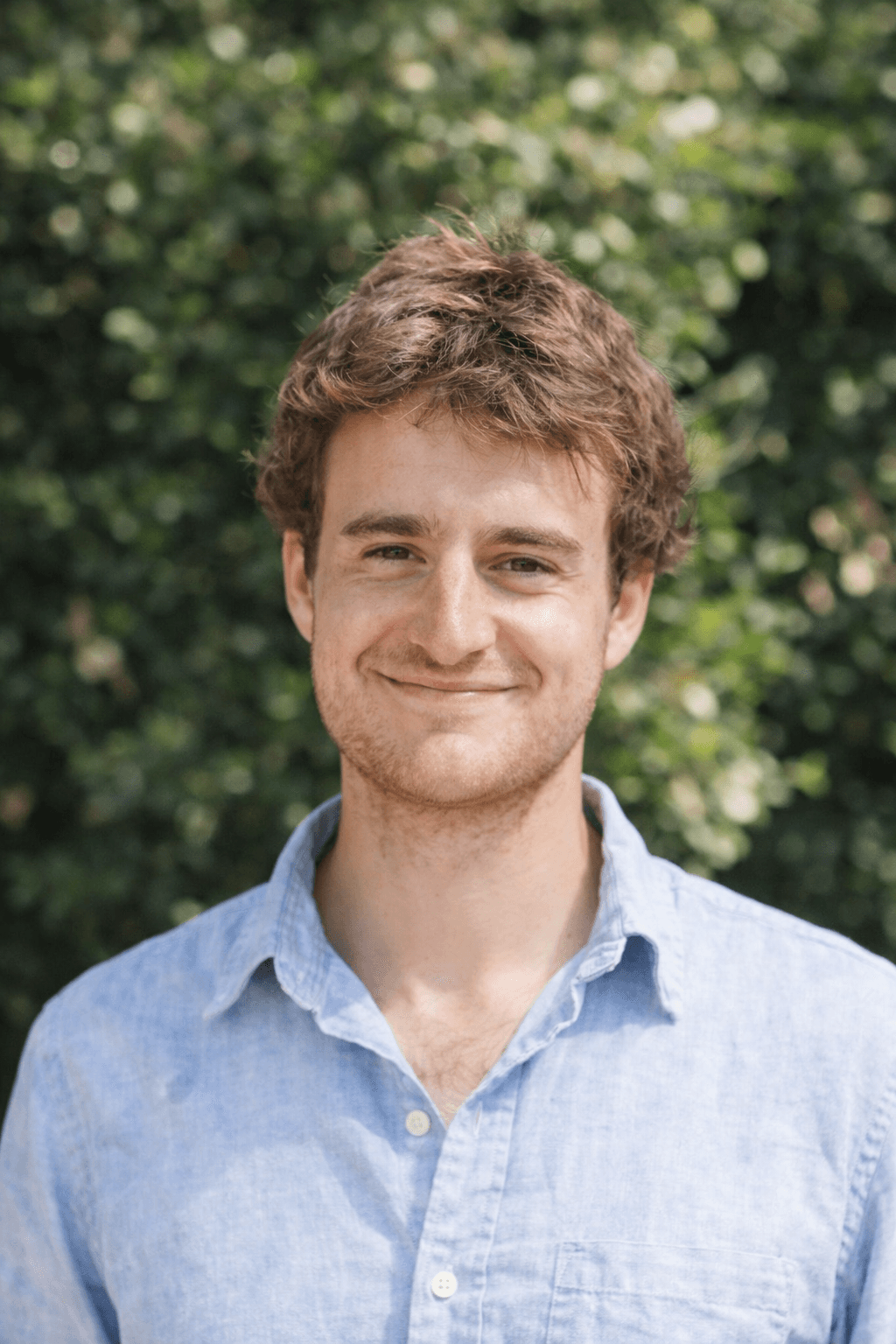 Black and white portrait of a smiling person with curly hair