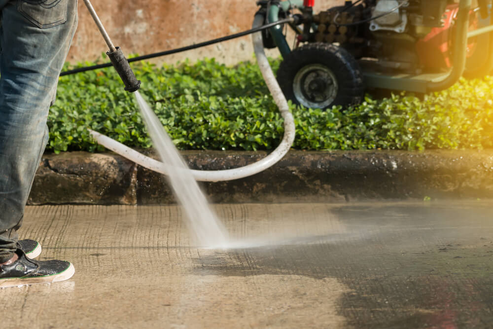 A person pressure washing the street