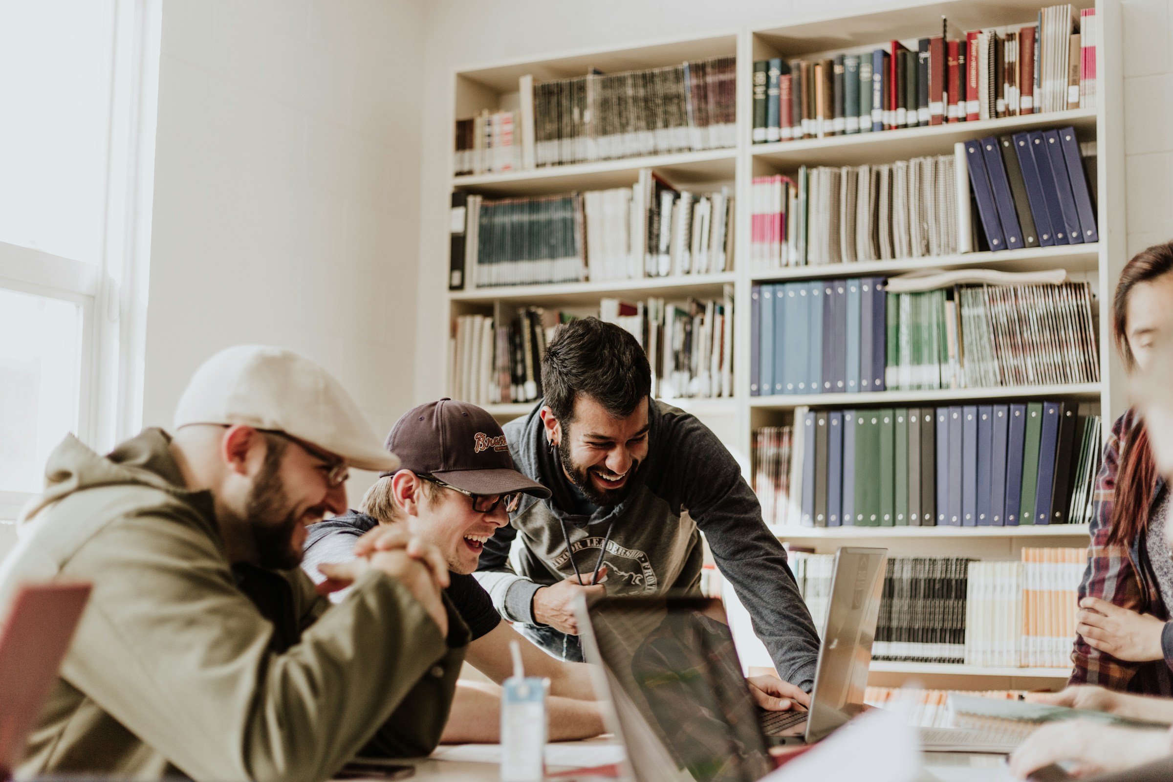 team looking at laptop - How To Get AI To Write An Essay