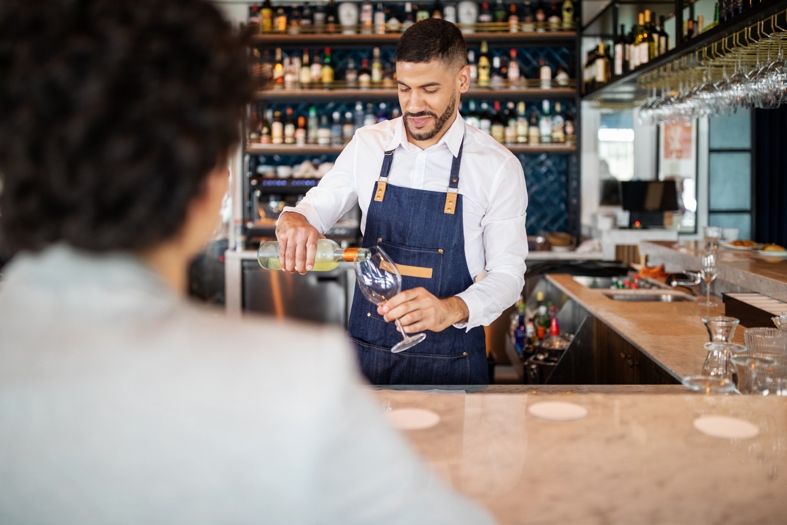 Café worker hands a takeaway coffee to a customer.