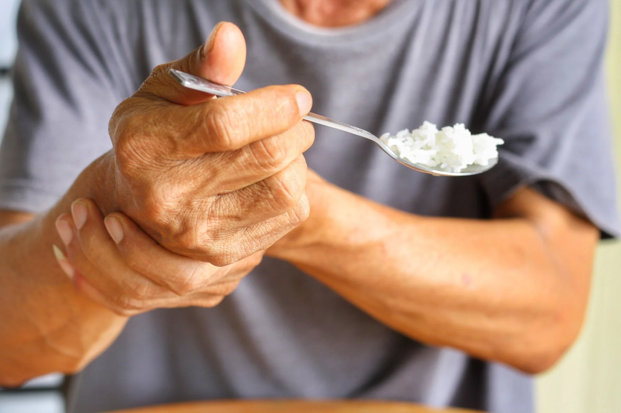 person with a tremor using a spoon
