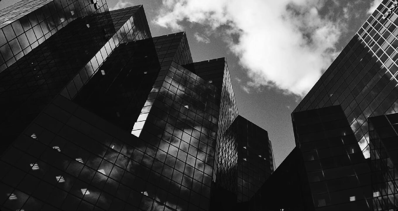 Abstract black-and-white photograph of modern corporate architecture as a symbol of stability, control, and trustworthy IT and platform structures in regulated enterprise environments by lennlay