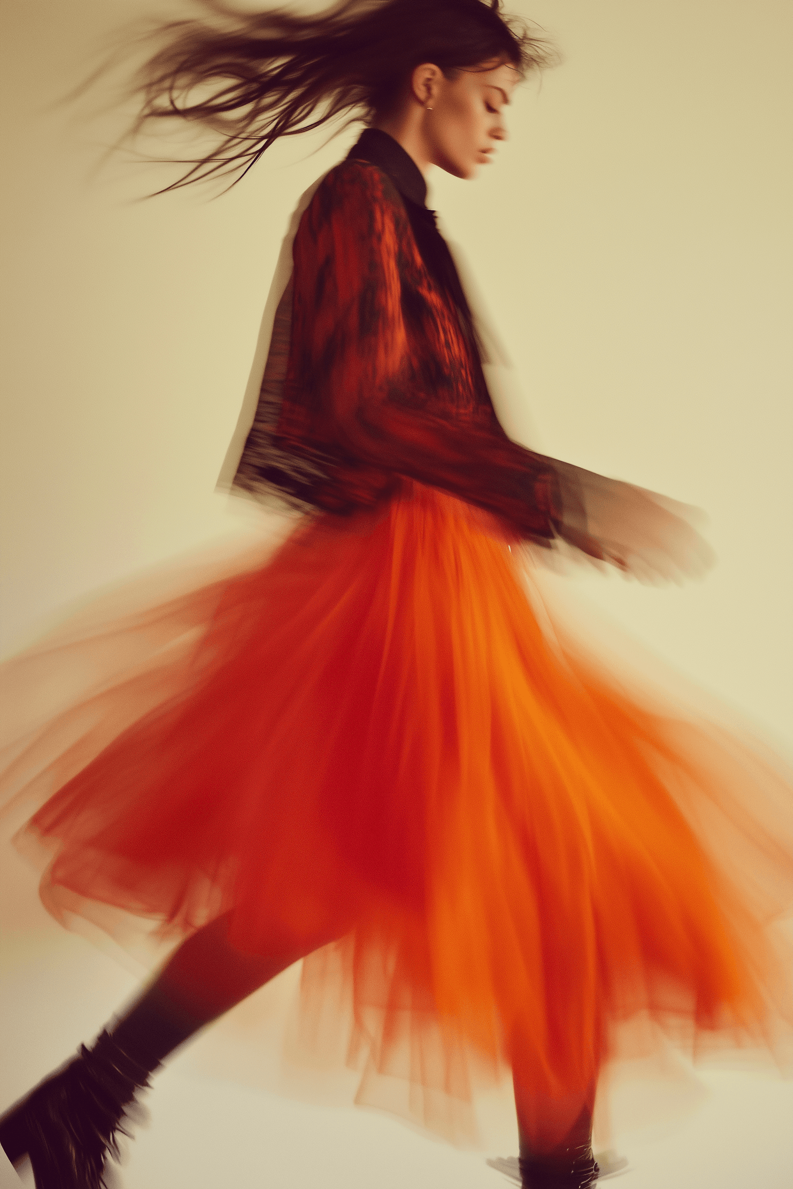 Dancer in a flowing orange dress captured mid-spin with dramatic motion blur.