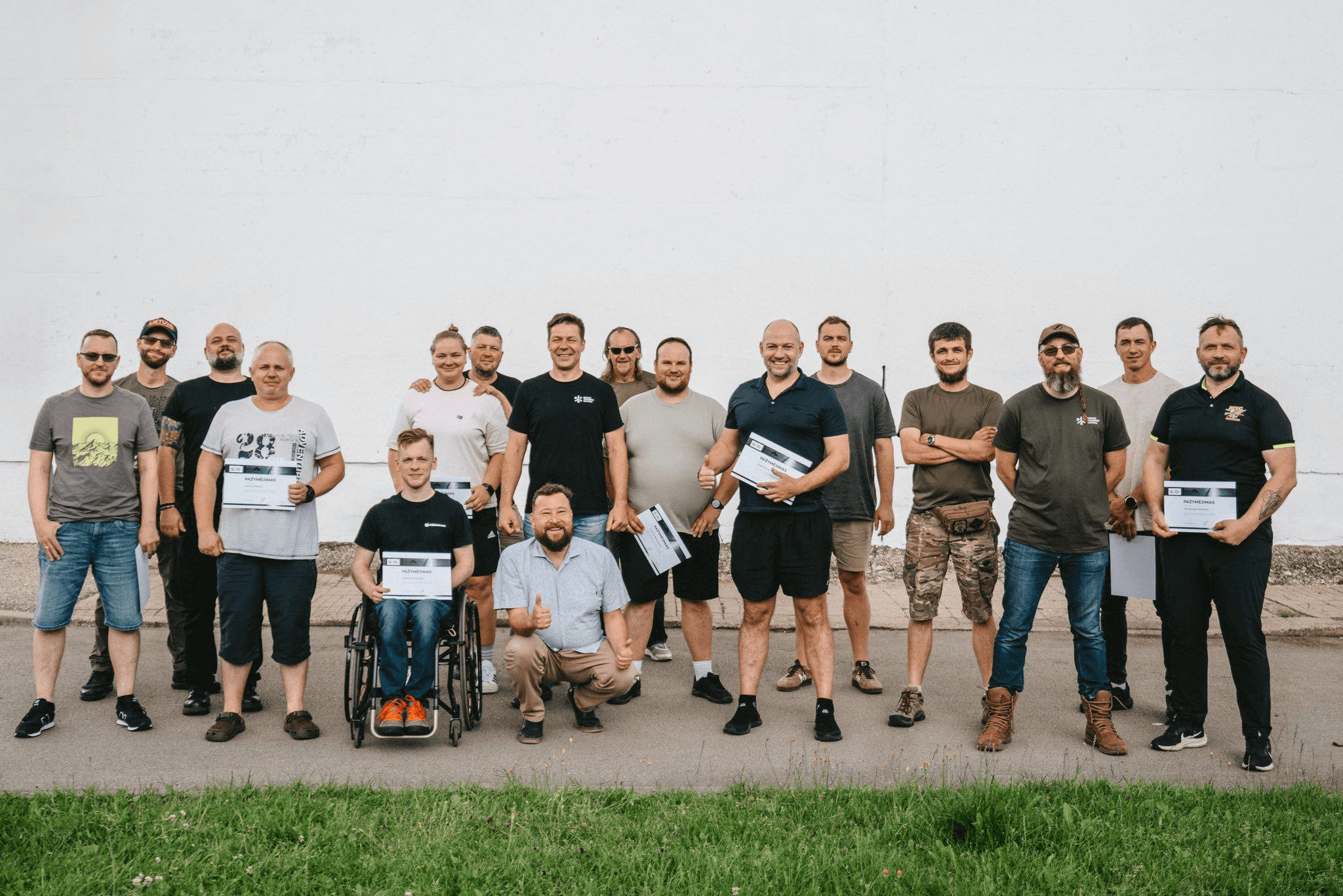 Larger group of men posing with course completion certificates