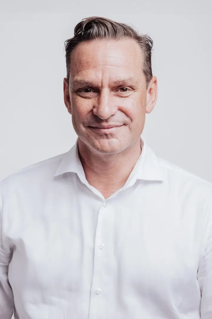 Professionelle Gastronomie- & Interieur-Fotografie: Gemütliche Lounge-Ecke mit rotem Sessel und beleuchteter Wein-Präsentation, inszeniert mit warmem Ambient-Licht und Fokus auf Design-Details.