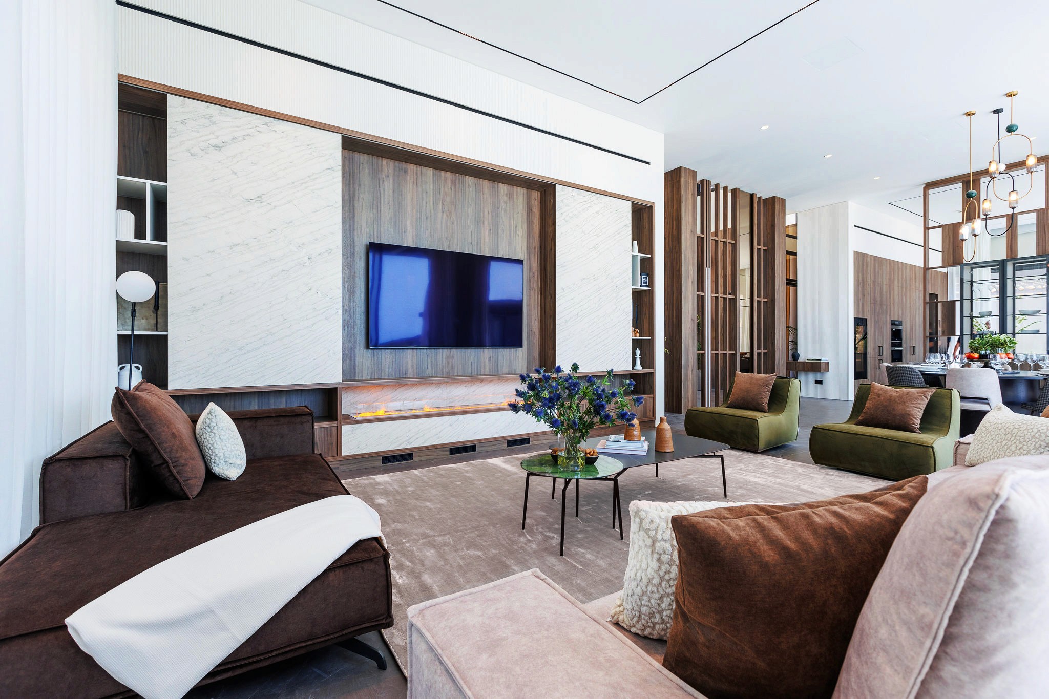 Villa Trio living room with custom TV wall, neutral seating, and open-plan layout