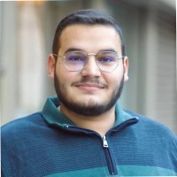 woman staring directly at camera near pink wall