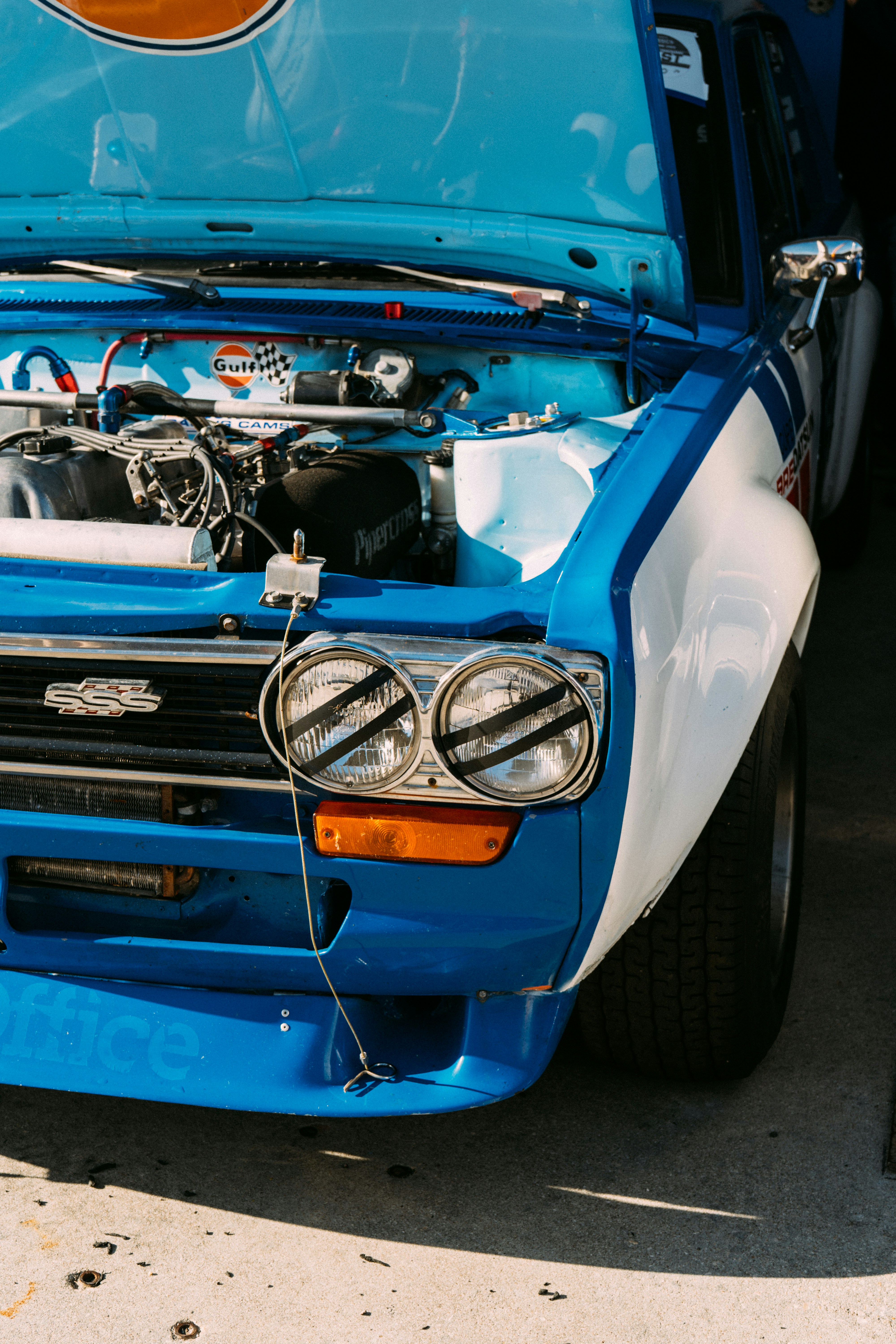 Blue and white racing car with hood open
