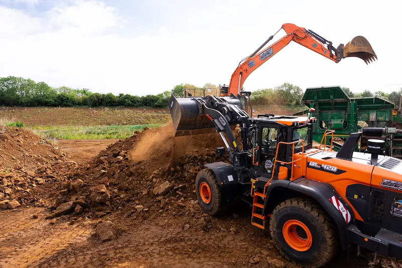 Doosan DL420 wheel loader excavating bulk earthworks on a UK civil engineering and controlled demolition project