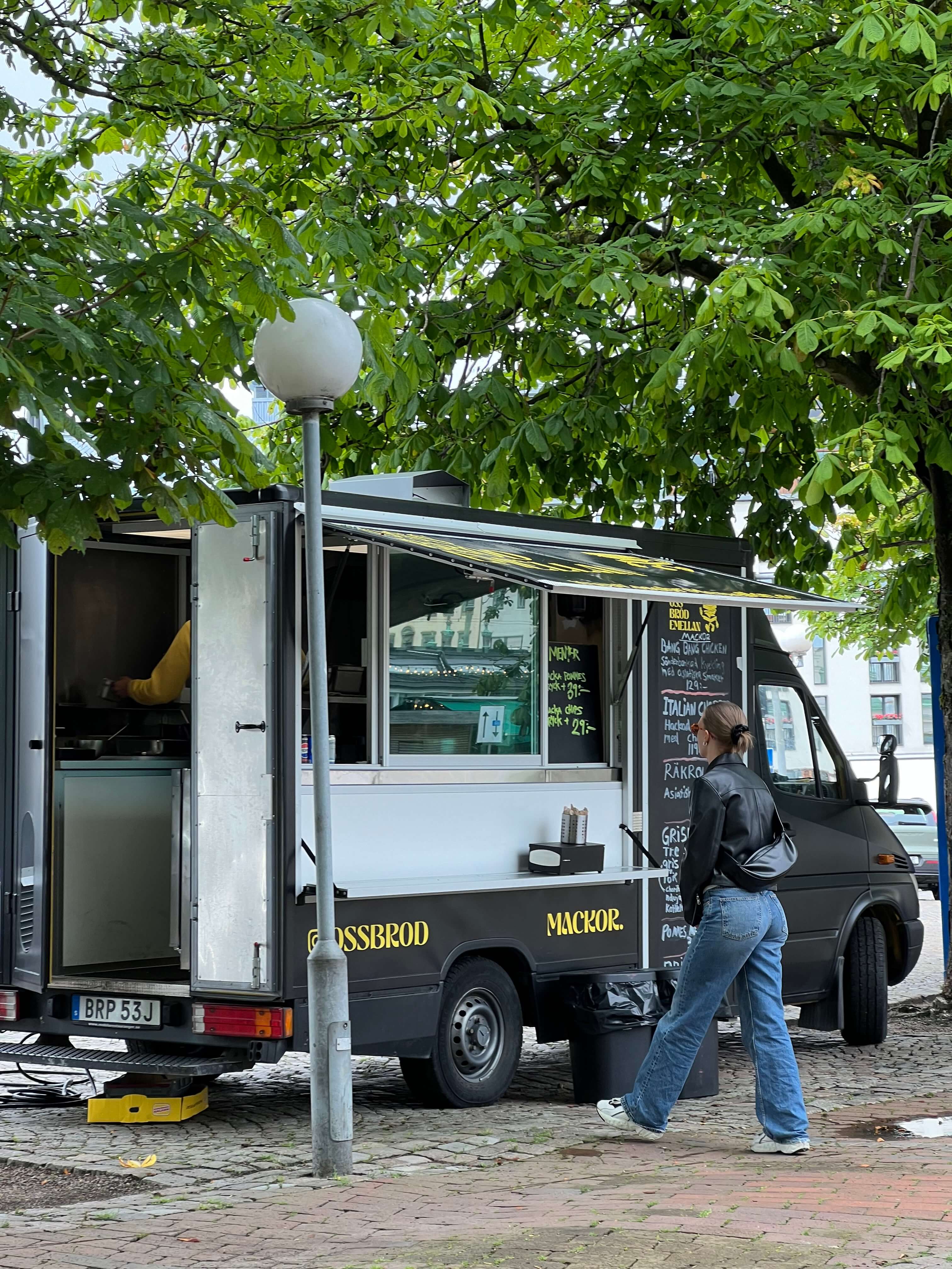 Kund beställer mat från Oss bröd emellan foodtrucken vid Kungstorget i Göteborg