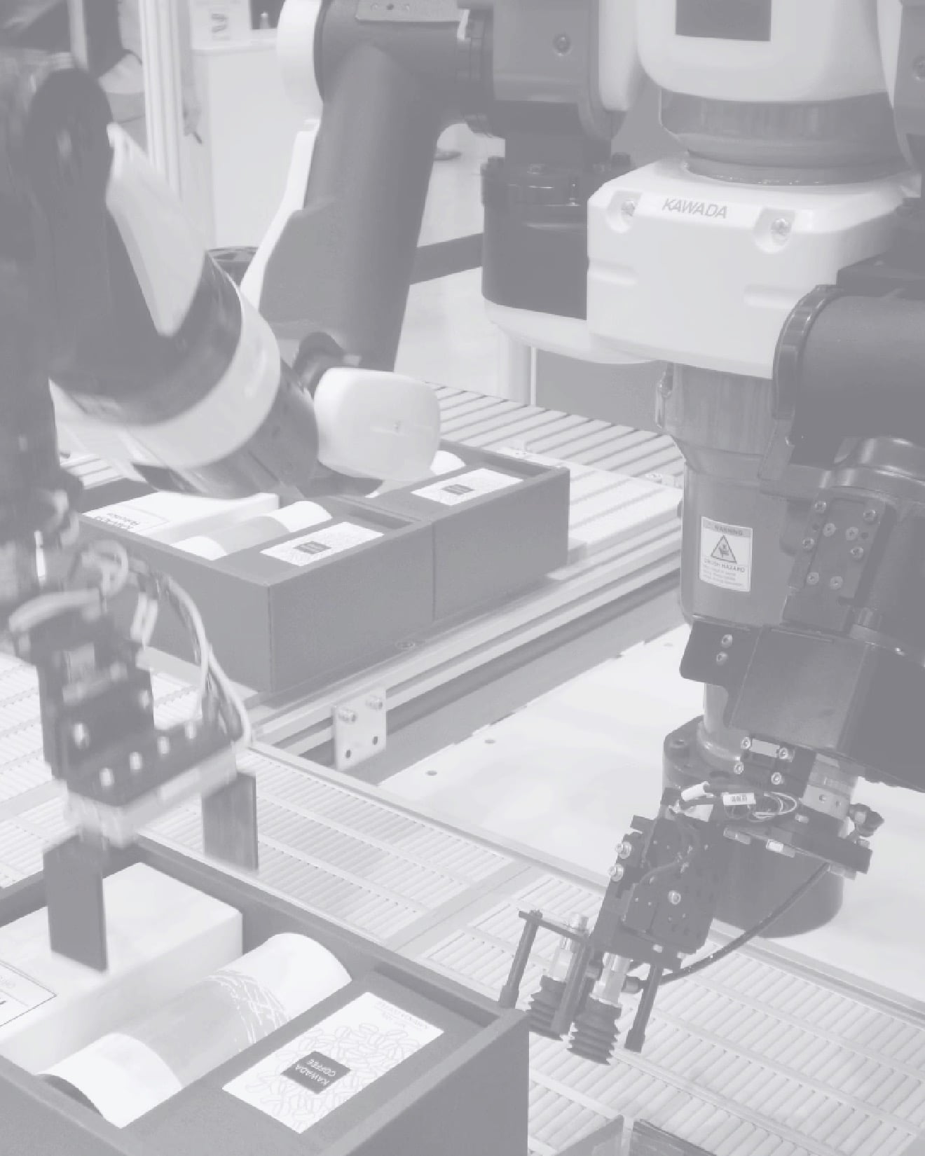 Roboterarme sortieren Pakete auf Fließband in Fabrik, zeigen moderne Automatisierung.