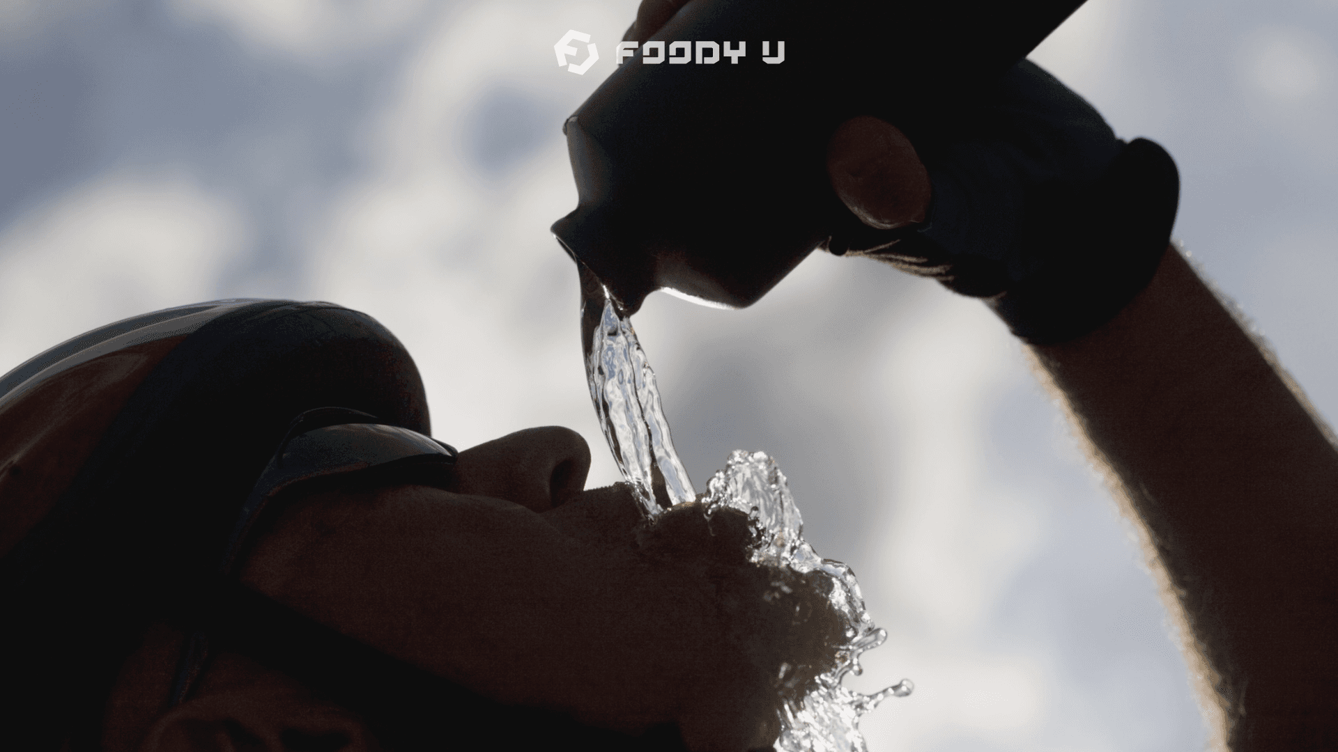 Athlete rehydrating outdoors, water pouring from sports bottle, Foody U logo visible — nutrition blog on dehydration