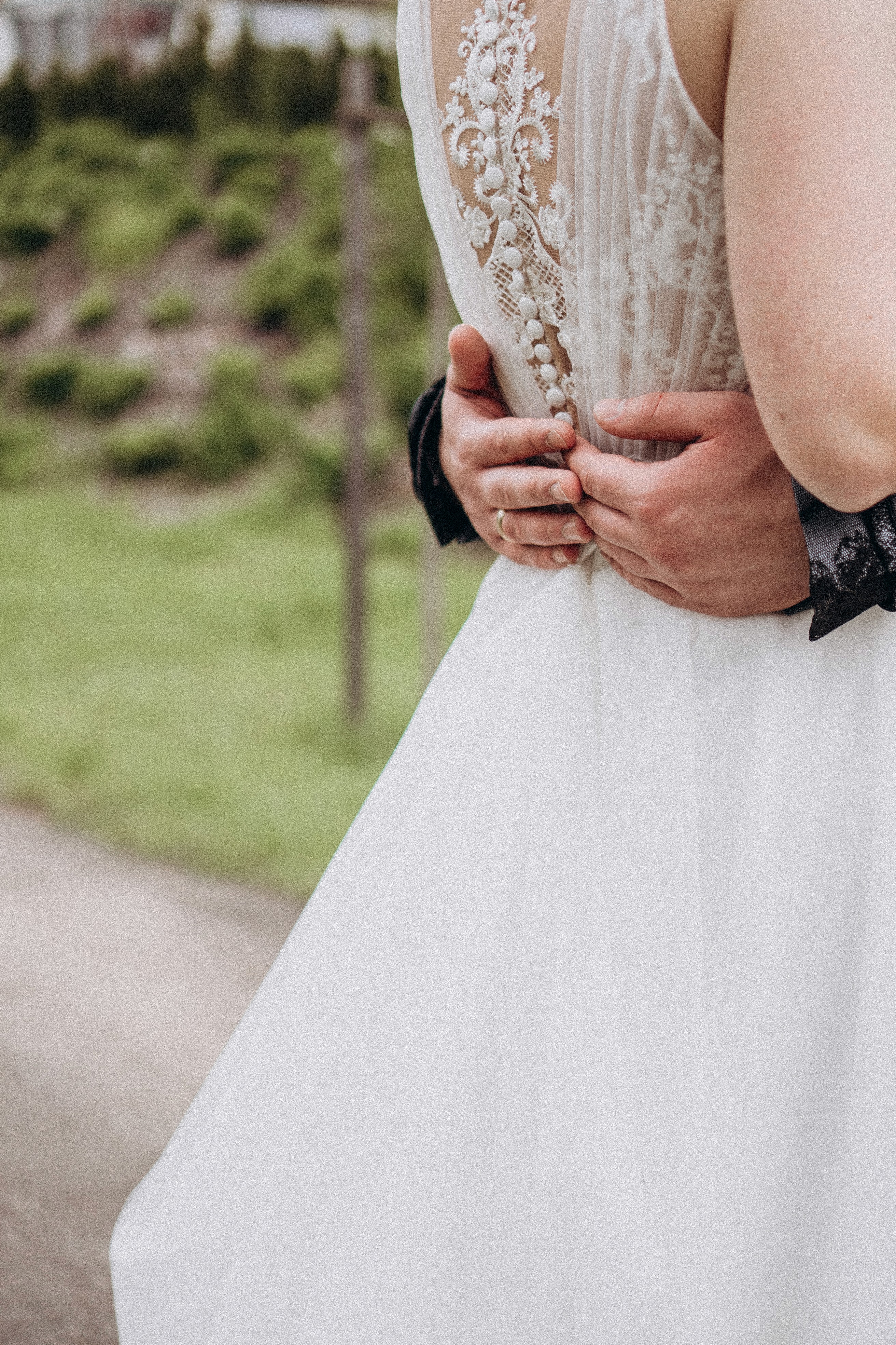 Detailaufnahme Brautkleid in Bogen, Bayern – Hände der Braut bei natürlicher Hochzeitsfotografie.