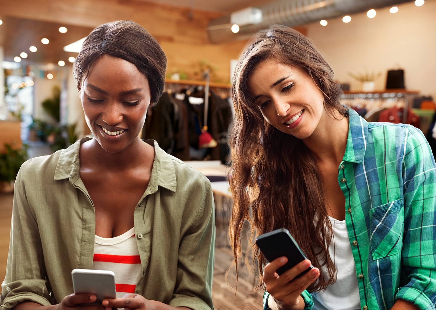 Commessi e commesse all’interno di un negozio di abbigliamento si scambiano commenti mostrandosi a vicenda lo schermo degli smartphone dove è presente il software HR
