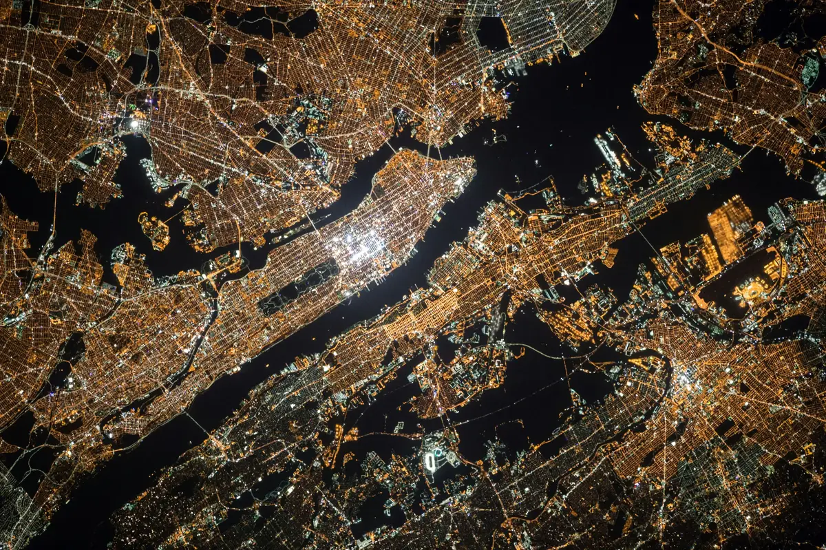 Una vista notturna di una città con luci brillanti e corsi d'acqua scuri