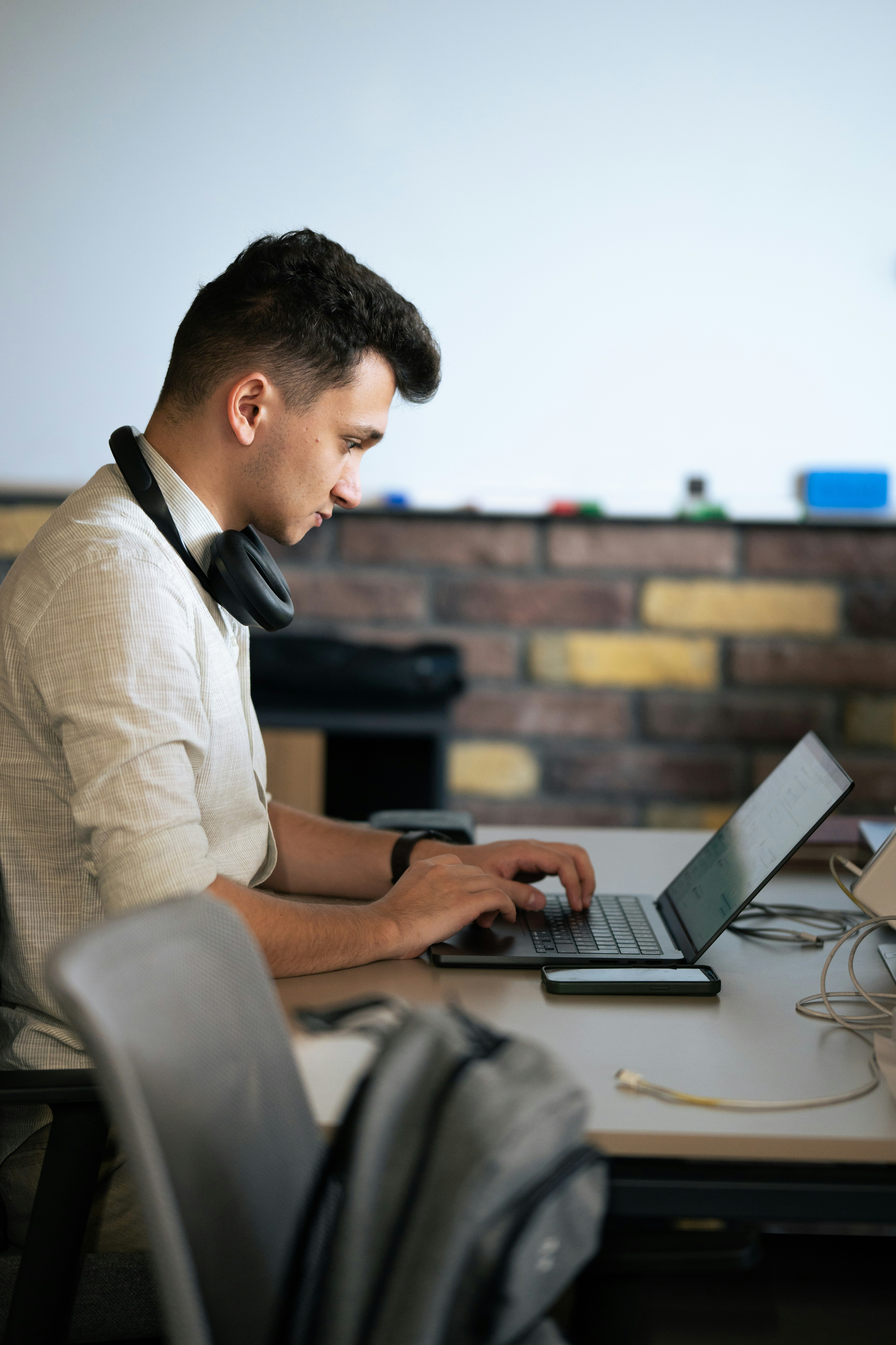 A man sitting at a table using a laptop computer