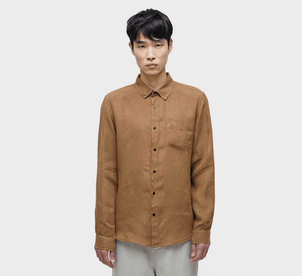 "Young man wearing a printed overshirt with graphic patterns and relaxed black trousers, showcasing contemporary urban fashion for men."