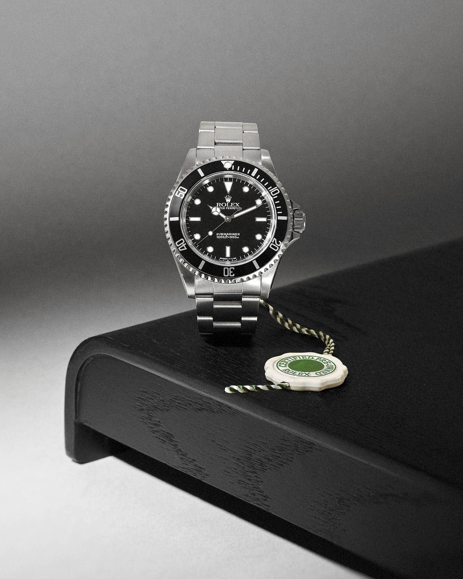 Luxury Rolex Submariner watch with stainless steel bracelet on black display.