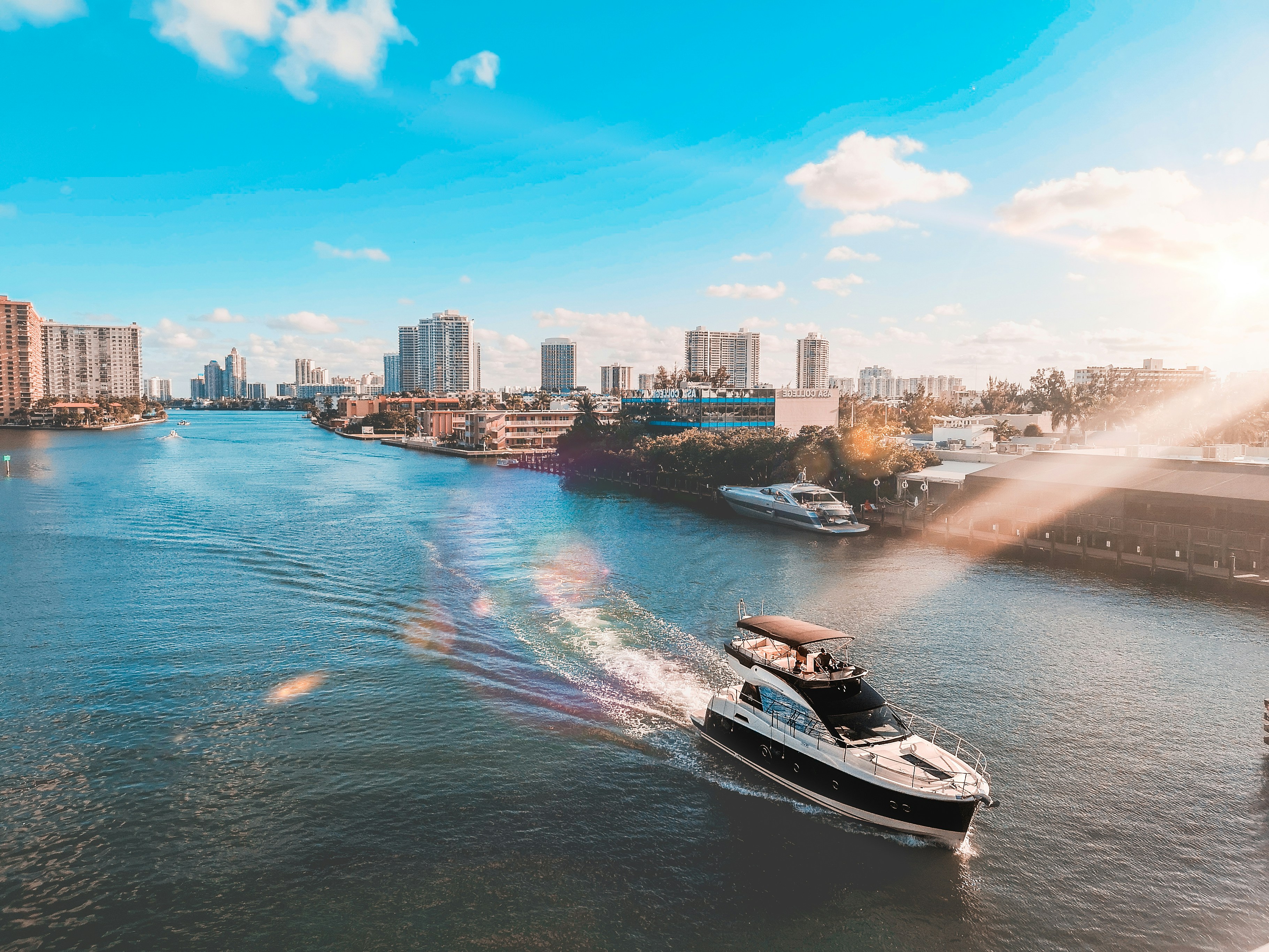 white and black boat on water near city buildings during daytime