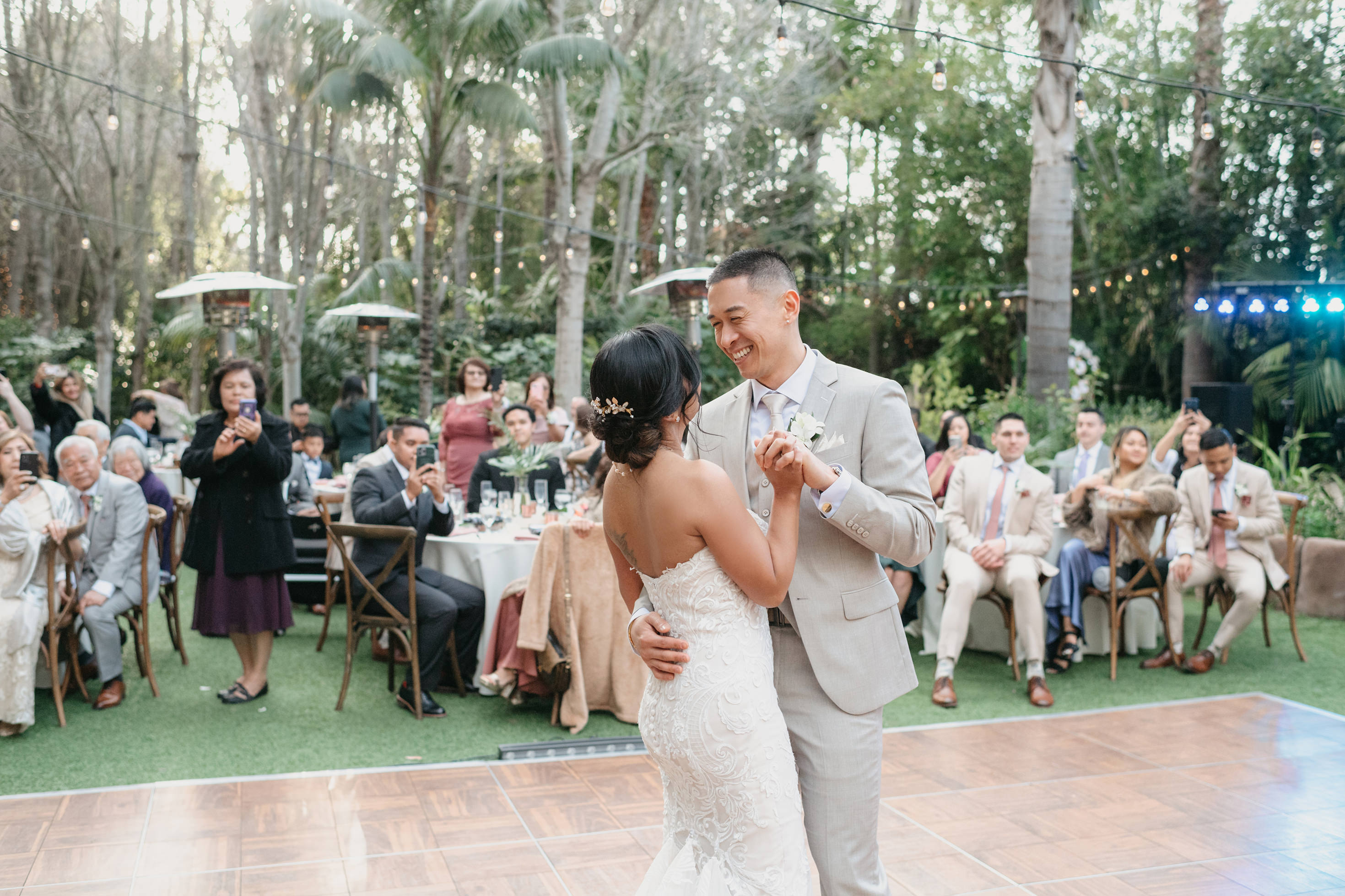 Bride and groom first dance with guests cheering