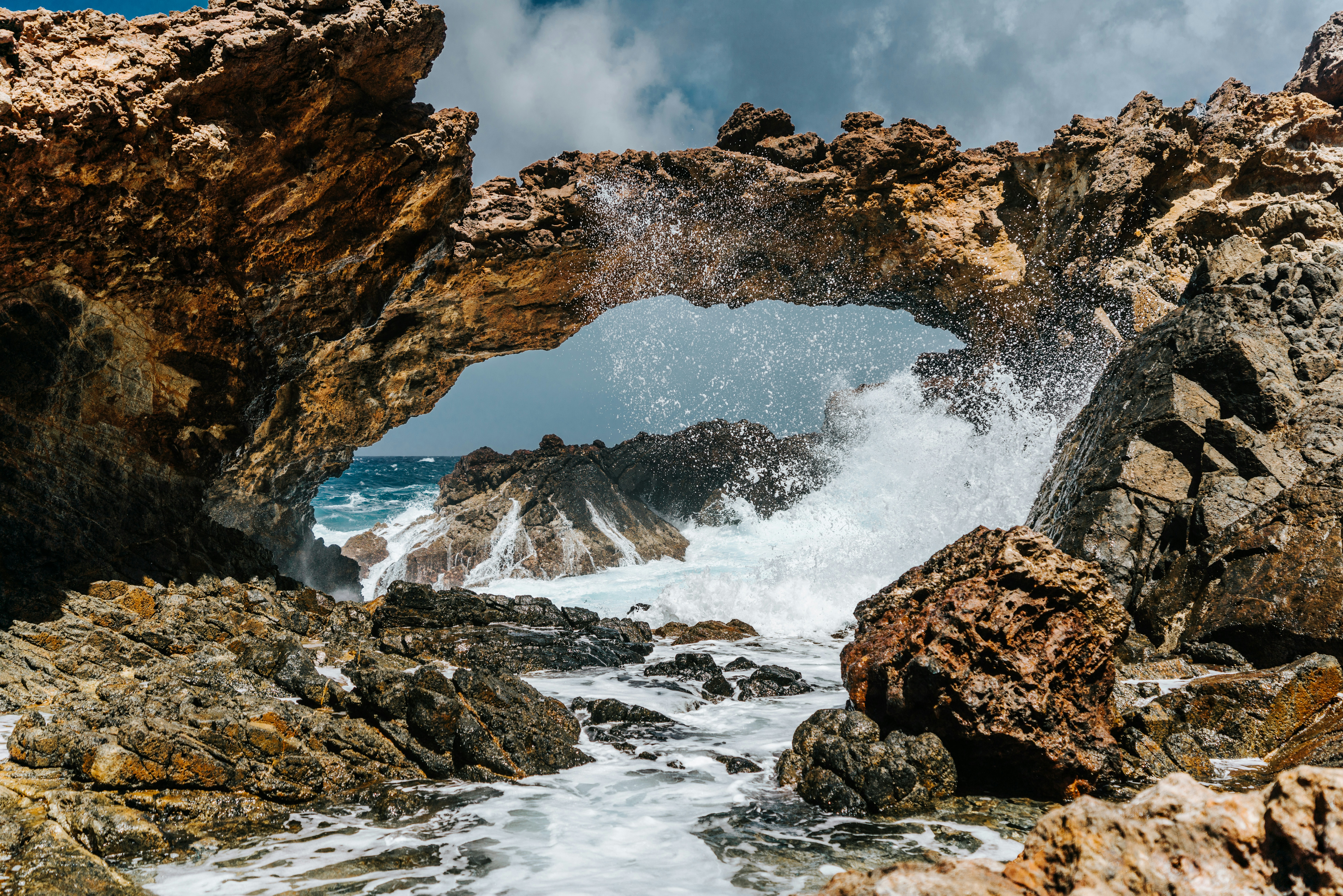 brown rock formation on body of water during daytime
