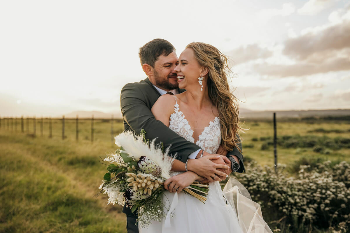 Groom embracing bride from behind during emotional wedding portrait