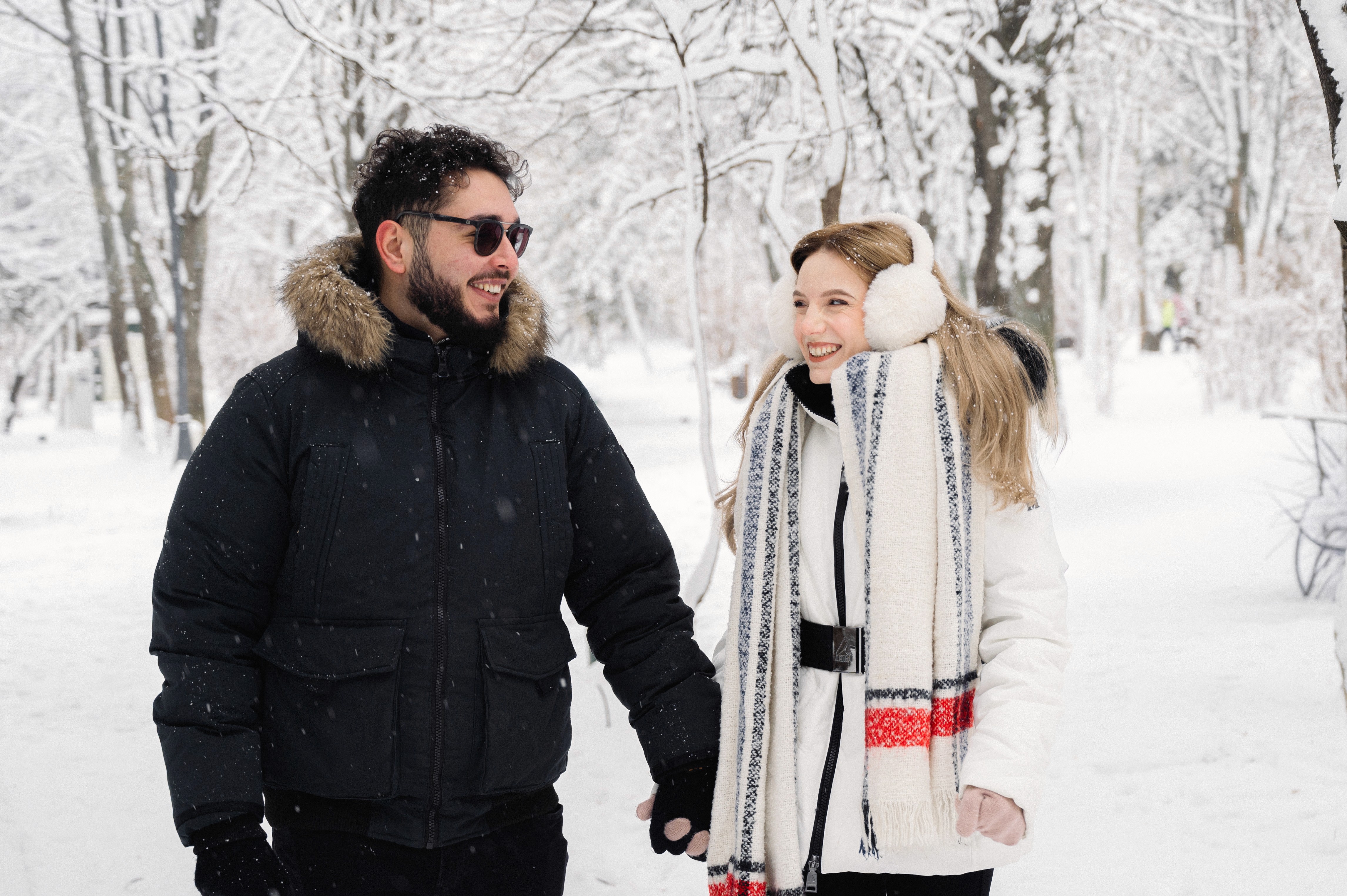 Ședință foto Save the Date realizată iarna, cu un cuplu elegant, într-un parc acoperit de zăpadă