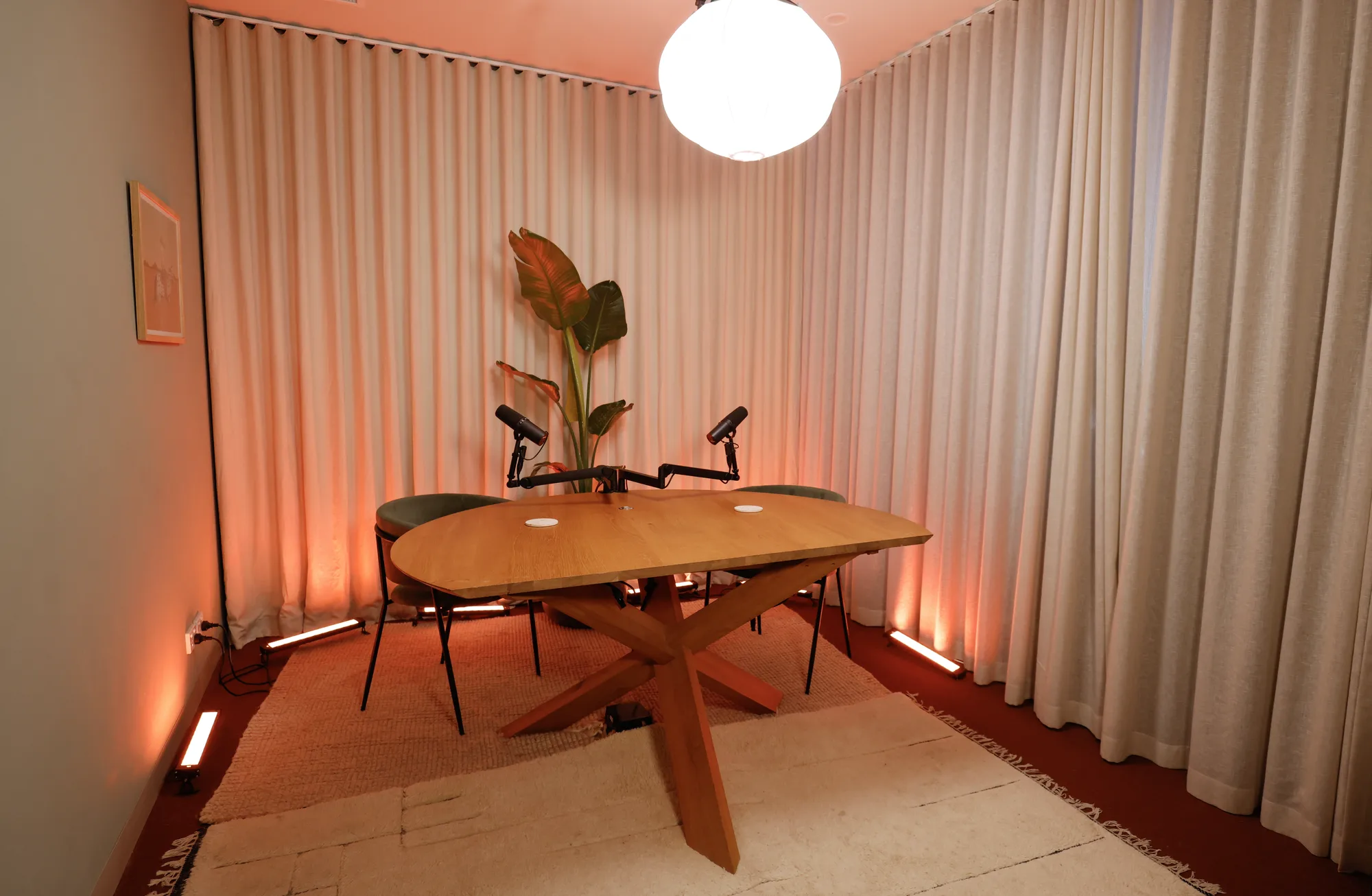 ARC set at Collingwood: an oval wooden table with microphones, framed by warm curtains