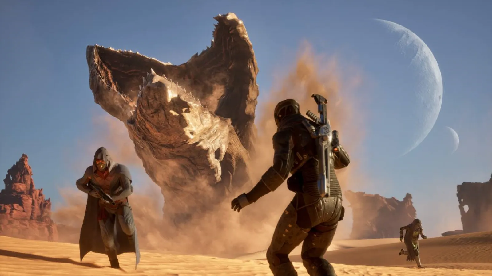 A group of armoured figures confronts a massive, sand-coloured alien creature rising dramatically from a desert landscape, under a clear sky with a visible crescent moon in the background.
