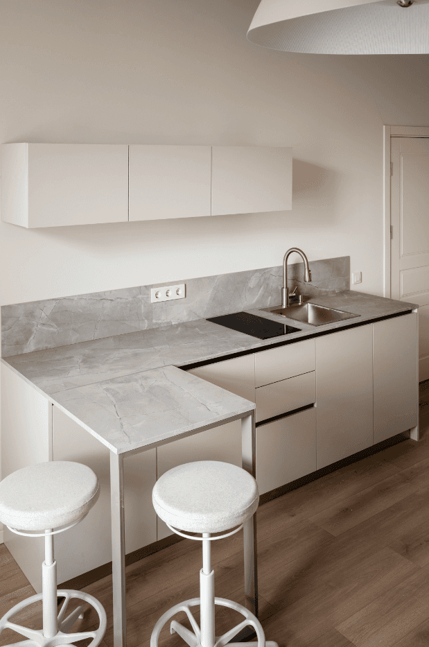 Bright, airy interior with arched doorways, wooden furniture, and a view of greenery outside.