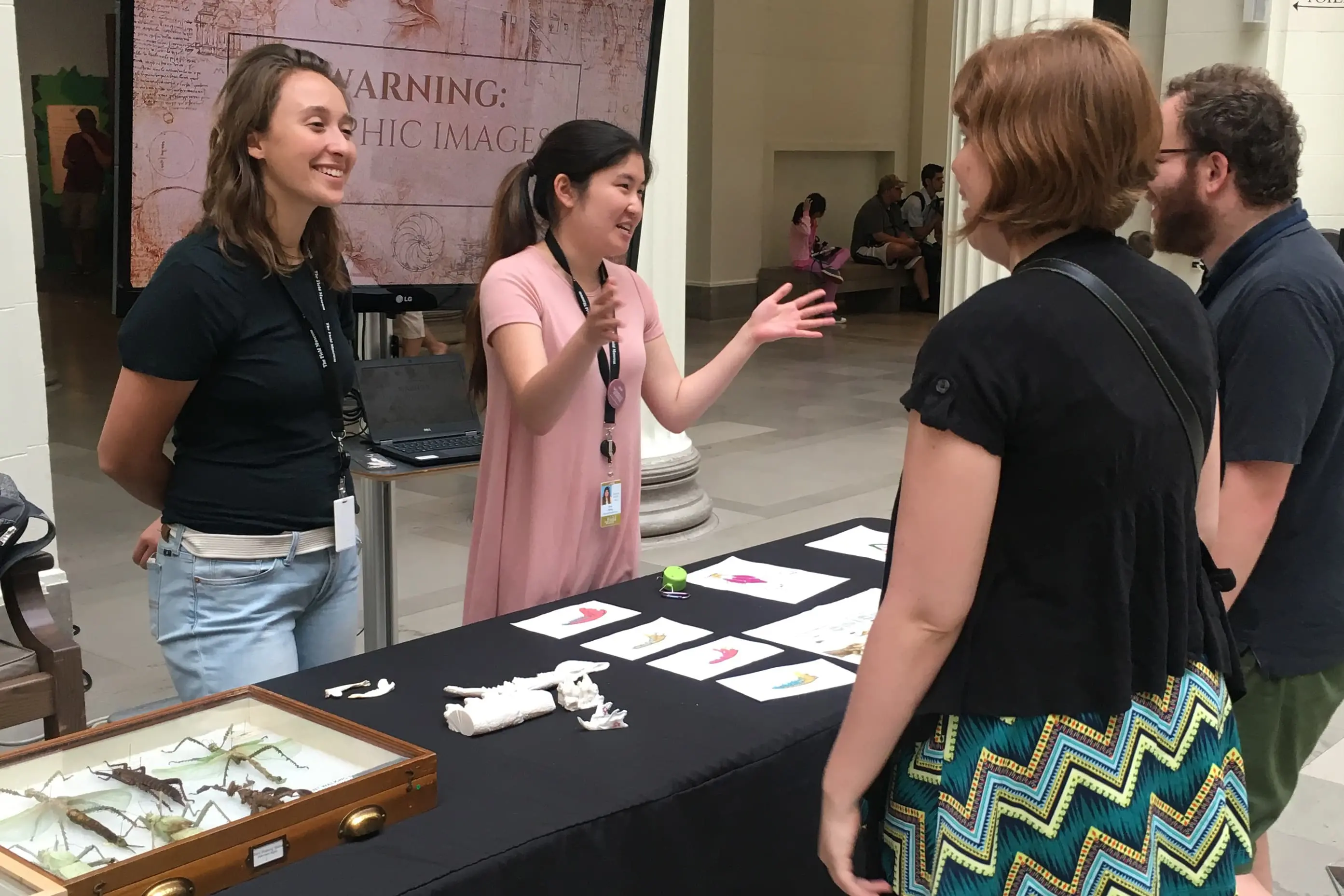 High school students engaging in STEM outreach at a RISE Research summer program explore science exhibits with interactive displays and expert guidance.