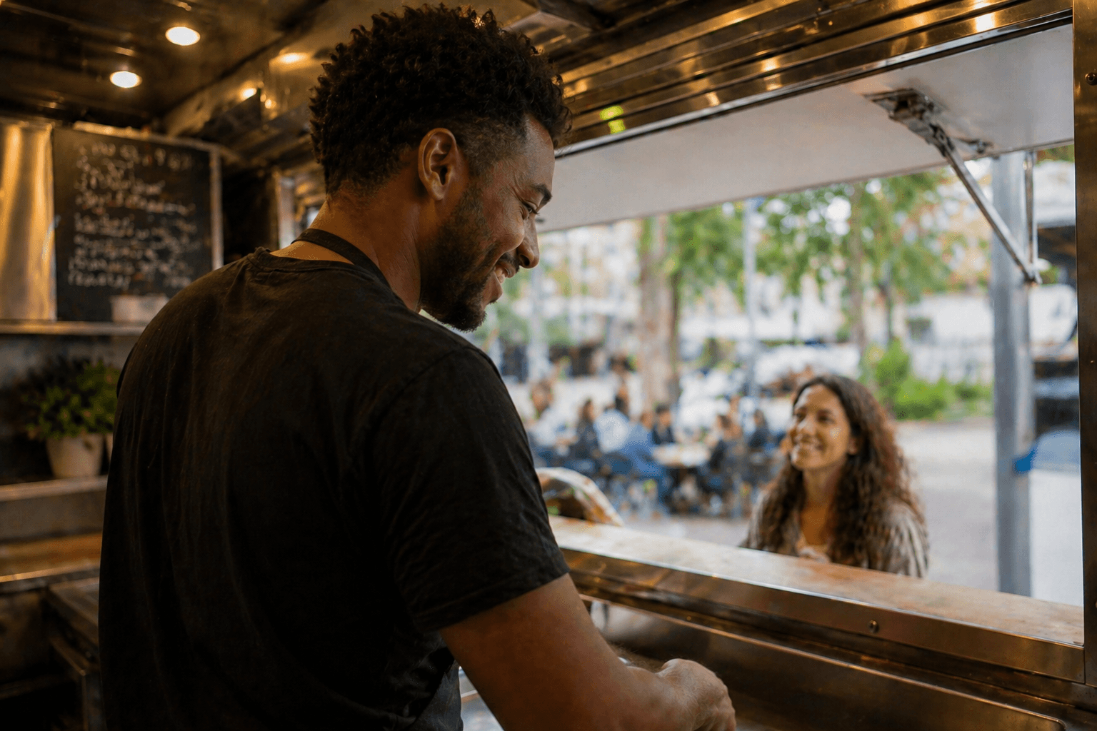 The owner of a food truck is serving a customer.