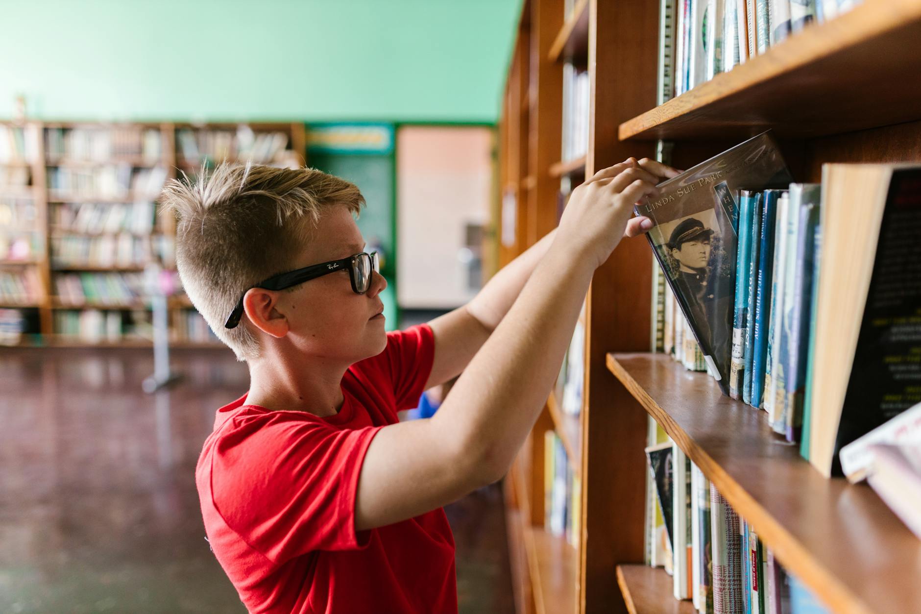 A close-up of a teacher's hands flipping through colorful pages to select the best big books for a reading corner.