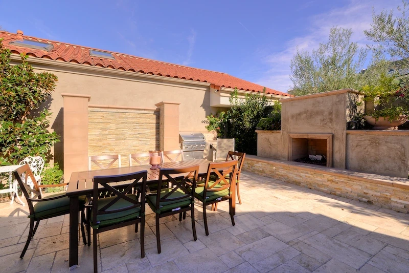 Patio dining space with fireplace and privacy walls in Harbor Ridge Transitional Remodel.