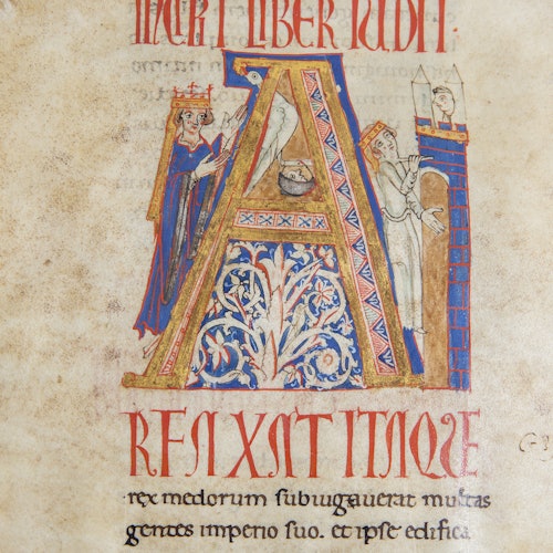 Illuminated manuscript with large letter "A" decorated with intricate patterns, featuring two crowned figures and Latin text underneath.